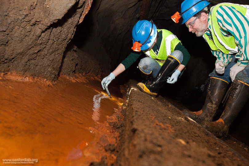 Two Scientists taking soil samples in underground cave
